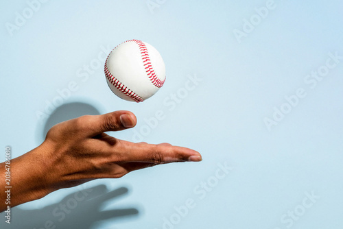 фотографія Hand tossing baseball mid-air photo