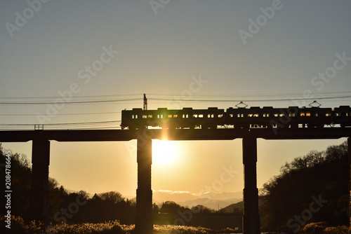 Cuadro en lienzo 夕陽を背景に陸橋を走る列車
