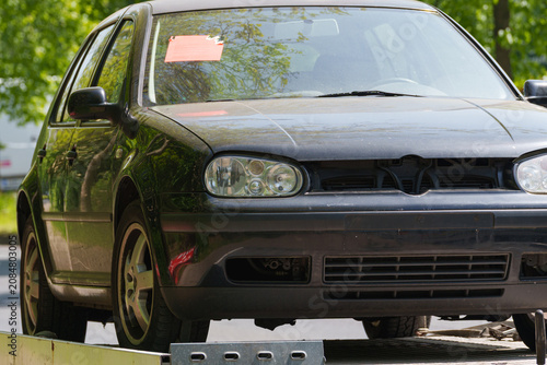 Passenger car secured on recovery trailer for roadside transport after breakdown