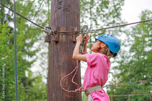 Φωτογραφία Close-up of a child wearing a blue sports helmet attaching a carabiner to a safe
