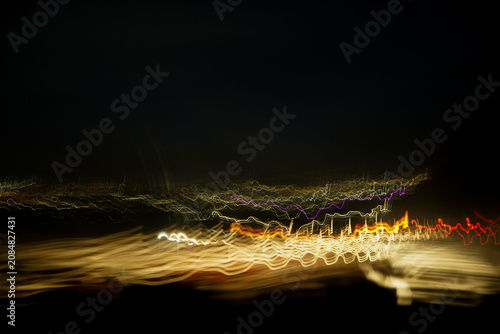 Foto Golden and red neon light waves in abstract long exposure night photography