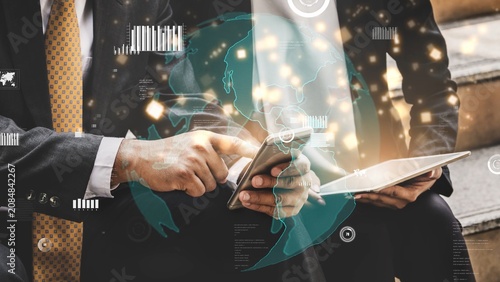 Two business professionals engage in a collaborative discussion  utilizing a smartphone and tablet amidst a backdrop of digital visuals and data elements. Xenic