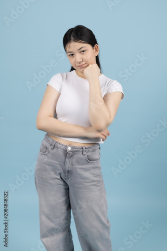 Pregnant woman standing sideways looking upwards touching her neck