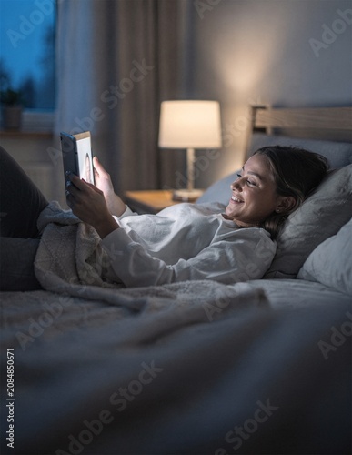 Woman Using Tablet In Bed At Night With Soft Screen Light Lifestyle