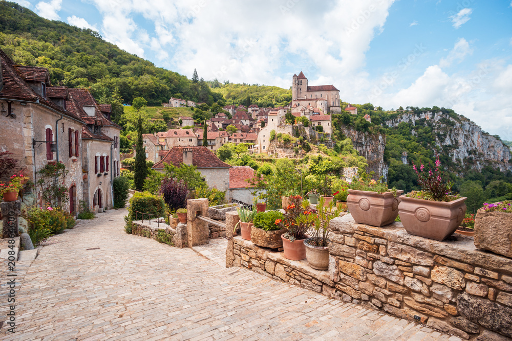 Fototapeta premium Vieille rue pavée menant au vieux village de Saint-Cirq-Lapopie, en Occitanie, France