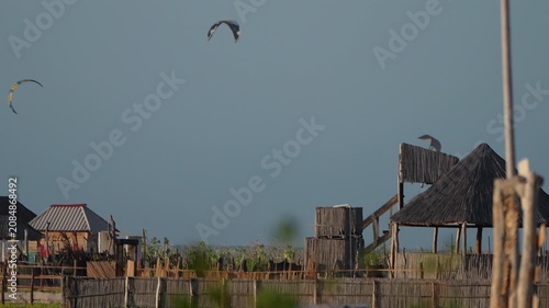 kitesurfing sails dipping behind a rustic beach structure in mayapo guajira colombia