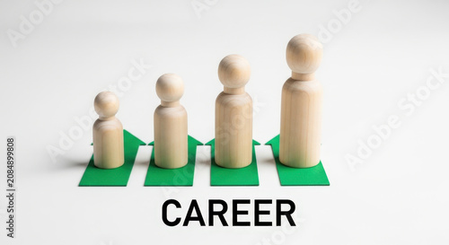Career growth concept with wooden figures standing on green arrows pointing up in ascending order against white background for business success.