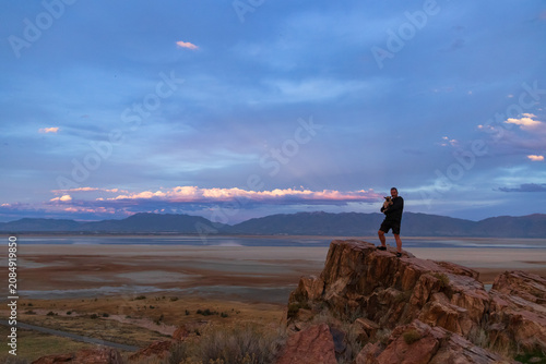 Foto Man holding a small dog overlooking the sunset over The Great Salt Lake at Antel