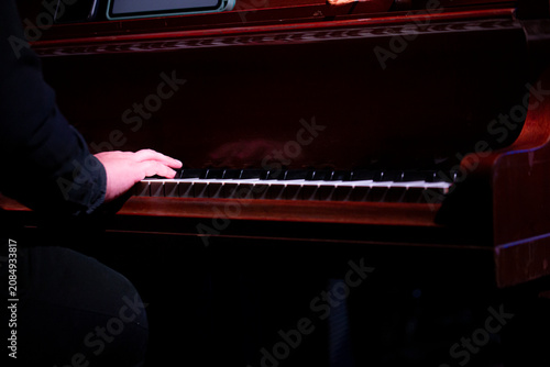 Photography Close-up details of jazz instruments and musicians performing on stage under dramatic blue and purple concert lighting, featuring saxophone, piano, drumsticks and live music atmosphere