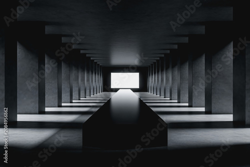 A minimalist monochrome interior corridor with concrete structures, a central black platform, and bright light at the far end, showcasing spatial perspective and geometric design.