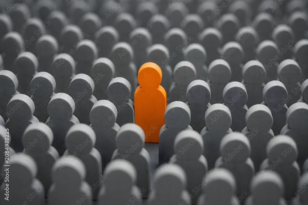 Fototapeta premium orange figure stands out from grey crowd