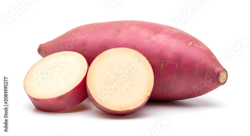 Whole and halved purple sweet potatoes on white background