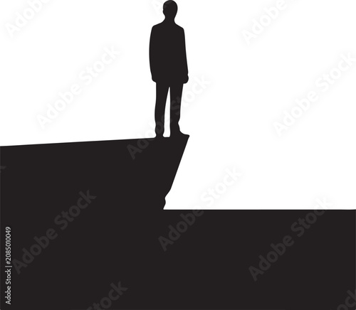 Silhouette of a businessman standing on the edge of a high cliff looking ahead