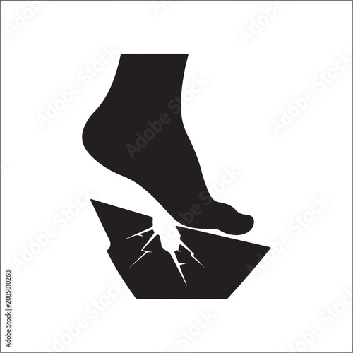 Black silhouette of a human foot stepping and cracking a solid surface