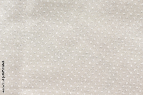 Cream cotton fabric with a small polka dot pattern