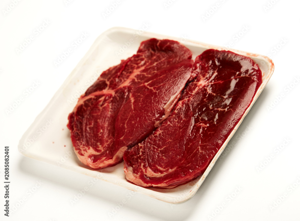 Obraz premium Raw beef steaks in food tray for butcher shop concept isolated on white background 