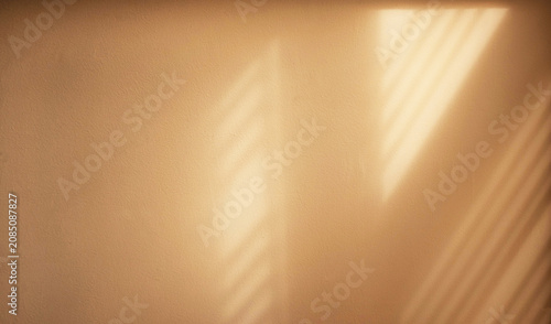 Warm sunlight casting soft window shadows on a beige wall. Creating a minimalist abstract background with natural light, texture and copy space.