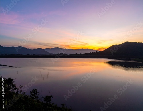 Background image of the reservoir. Beautiful sunrise or sunset sky over calm lake with reflection in surface water in the morning or evening. copy space. Lam Taphen Reservoir, Suphanburi.