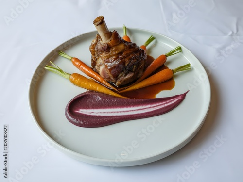 Roasted lamb shank with glazed carrots and purple puree vegetables culinary