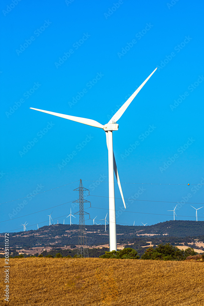 Fototapeta premium Large wind turbine with power lines in rural landscape