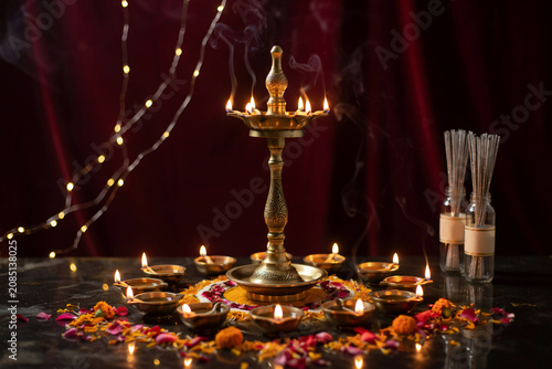 Traditional brass oil lamp with burning diyas, festive Diwali celebration with flower petals and fairy lights, spiritual Hindu prayer ritual setup
