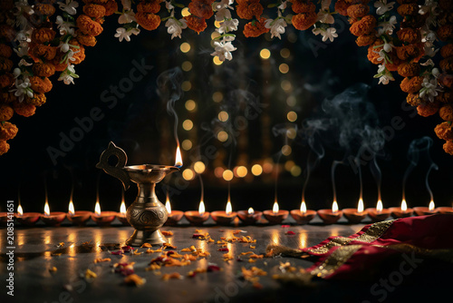 Diwali celebration background with brass oil lamp and marigold flowers, traditional deepavali diya lighting with smoke and bokeh, festive indian holiday decor
