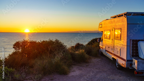 Foto Caravan on sea shore at sunrise.