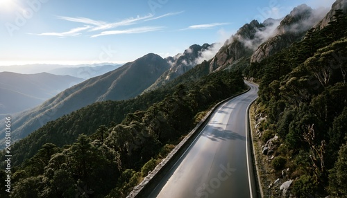 Scenic Mountain Road Winding Through Forested Highlands Under Clear Blue Sky
