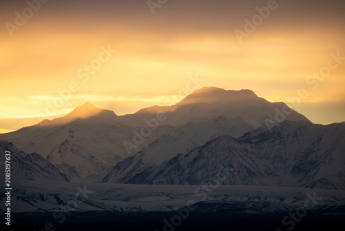 Fog over mountain at sunset in Alaska.