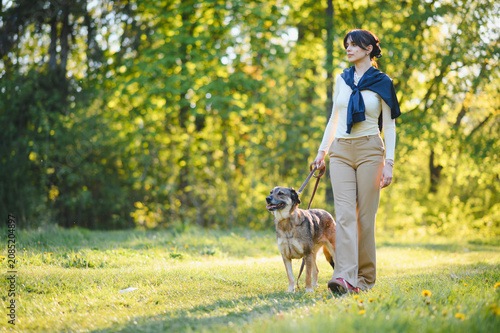 Schilderij op canvas Woman walking dog in park enjoying leisure time