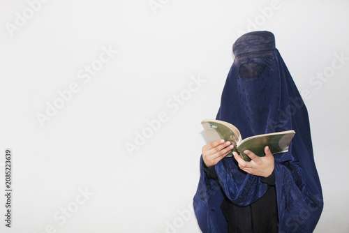 Tableau sur toile Afghan Muslim women with burka traditional costume, reading Book