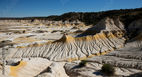 Dry Terraced Salt Fields in Arid Landscape with Geometric Patterns Under Clear Sky