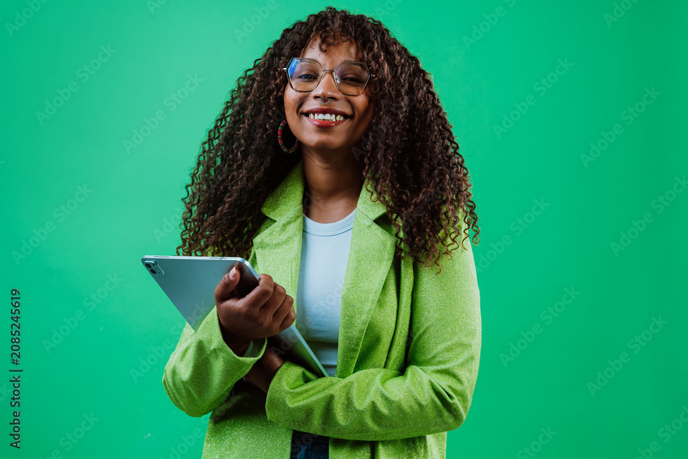 Fototapeta premium Smiling businesswoman using tablet on green background