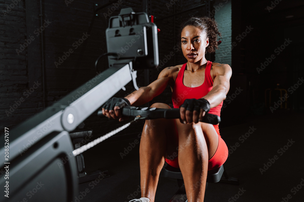 Obraz premium Fit young woman in red sport outfit making workout in the gym