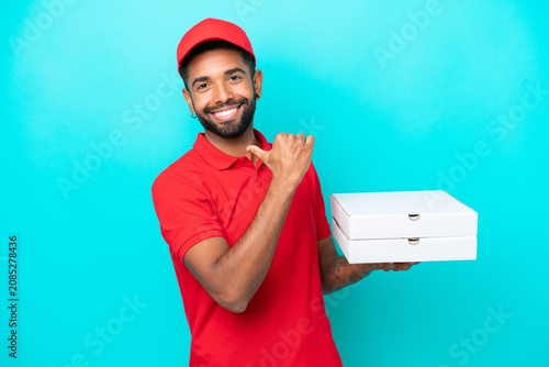 Cuadro en lienzo Pizza delivery Brazilian man with work uniform picking up pizza boxes isolated o