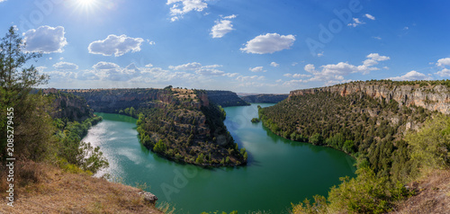 Duraton river carving deep canyon through limestone cliffs, creating winding meander in segovia, spain