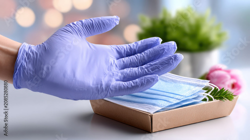 Disposable gloves and surgical face masks in box with gloved hand for hygiene and medical safety background for healthcare brochure