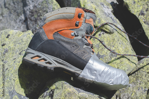 Hiking boots on a background of mountains. Boot wrapped with adhesive tape. Hiking	