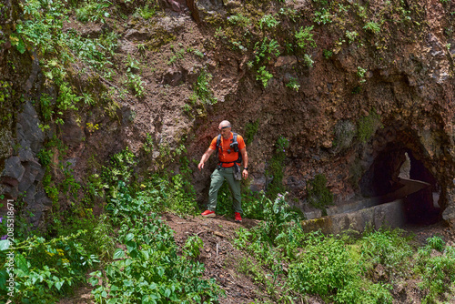Hiker approaching a rock tunnel
