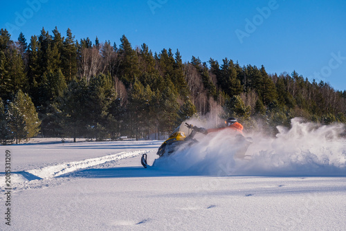 Konstfotografi Athlete on a snowmobile moving in the winter forest in the mountains of the Sout