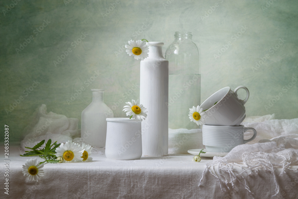 Wall Mural Contemporary still life with daisies and white dishes on a light background