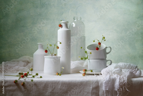 Photos Contemporary still life with strawberries and white dishes on a light background