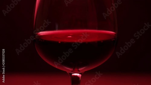 Red wine pouring glass with deep shadows