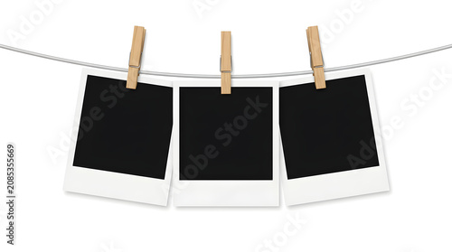 Three blank polaroid photos on a clothesline with clothespins