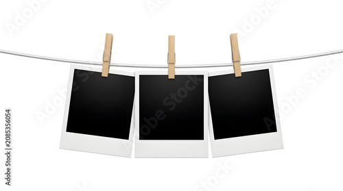 Three blank polaroid photos on a clothesline with clips