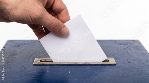 Person casting ballot into box with clipboard and hand