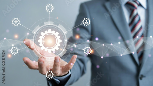 Businessman hand holding futuristic digital gear hologram for technology innovation and business process management