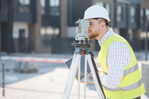 Картината върху платно Land surveyor engineer using total station at construction site