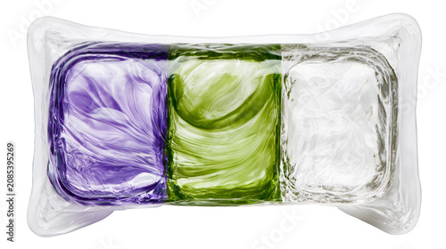 Foto Three colored glass blocks purple green and clear, encased in clear plastic wrap