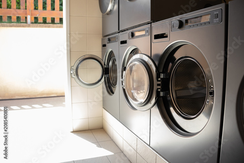 Fotografía Several washing machines and tumble dryers in a campground laundry room